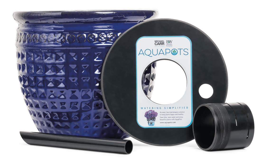 A cobalt blue textured ceramic planter beside black "AquaPots" self-watering system components, including a base disk, fill tube, and reservoir cup.